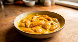 Pollo crudo marinando en salsa amarilla de cúrcuma y leche de coco para Satay